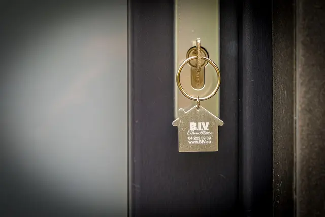 Porte-clés B.I.V. immobilier accroché à la serrure d'une porte d'entrée