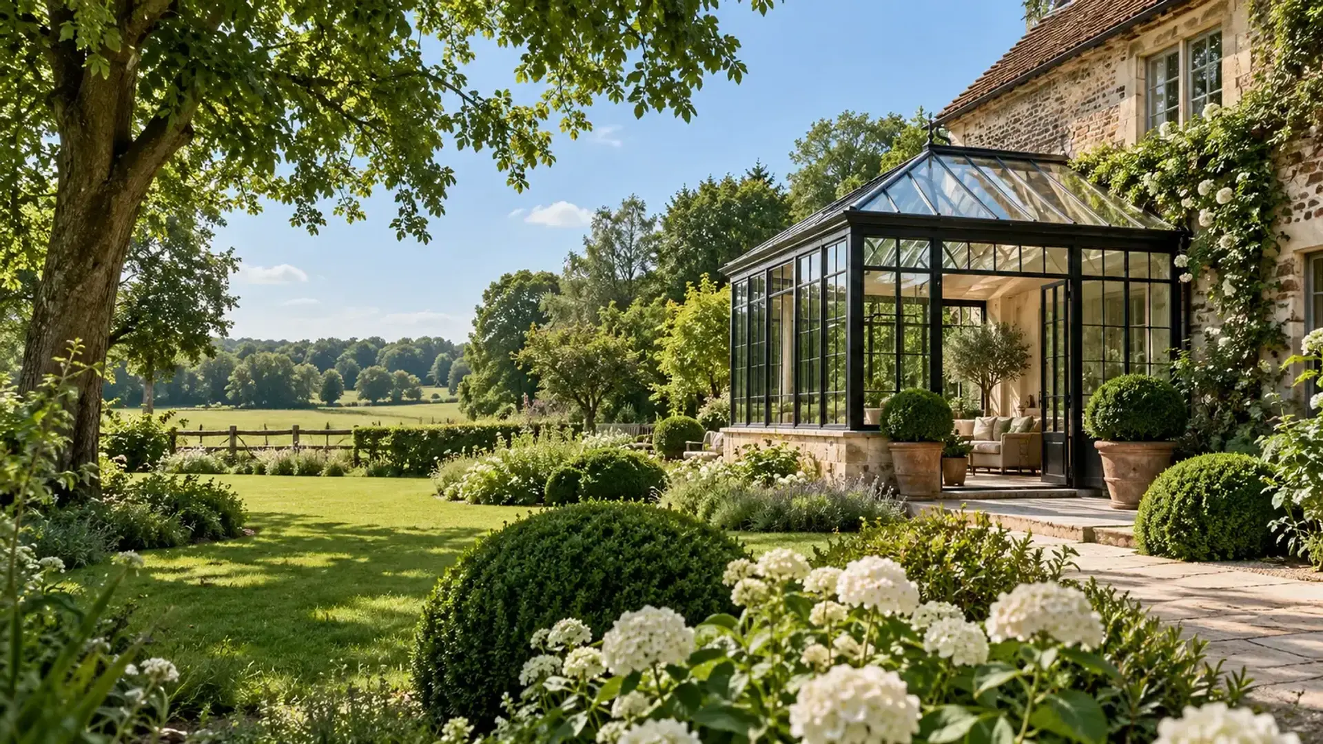 Stijlvolle groene tuin met oranjerie en zicht op de weide