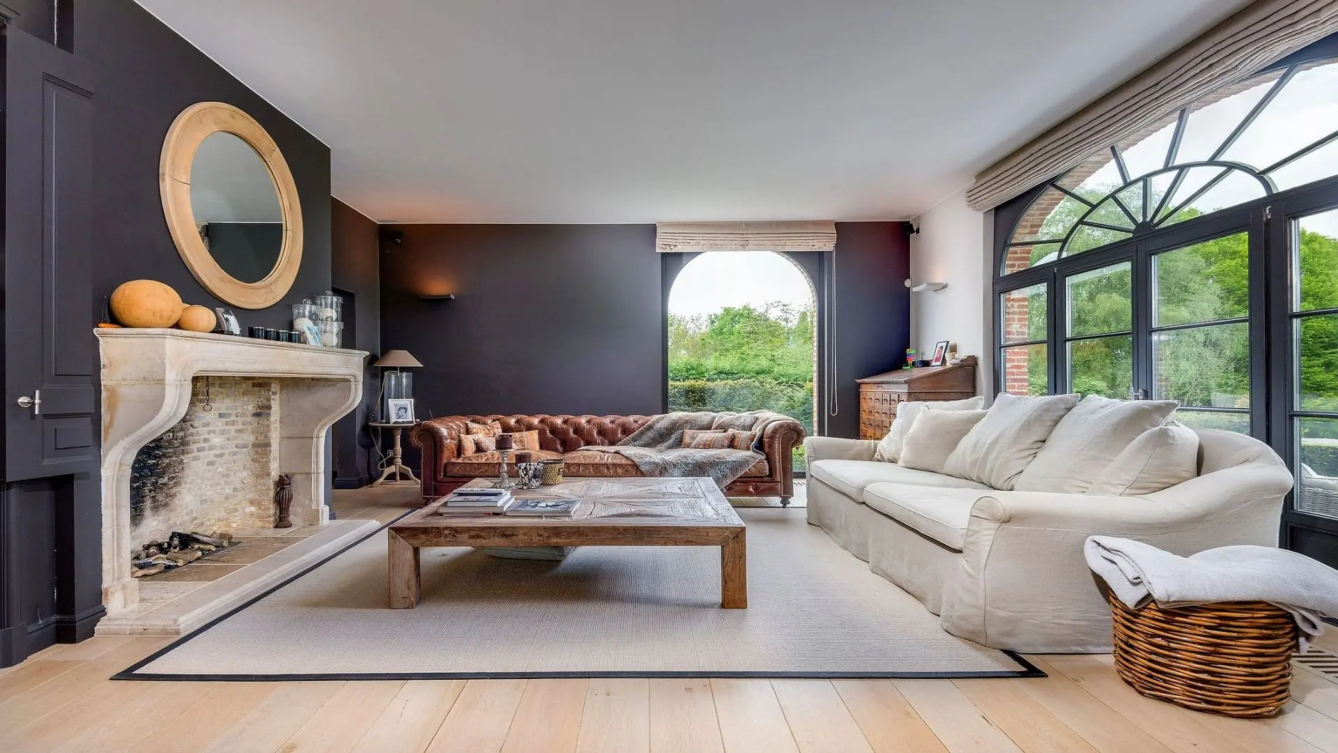 Warm landelijk interieur met haard en zicht op het groen