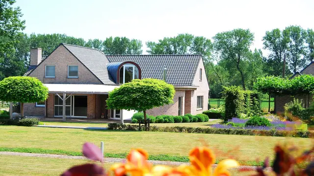 Bakstenen villa met tuin en volwassen bomen