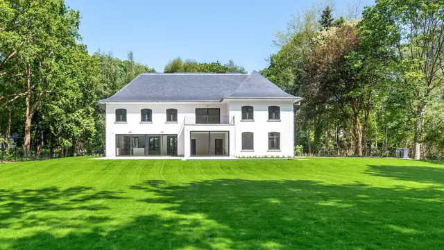 Statig herenhuis met symmetrische gevel omgeven door bomen